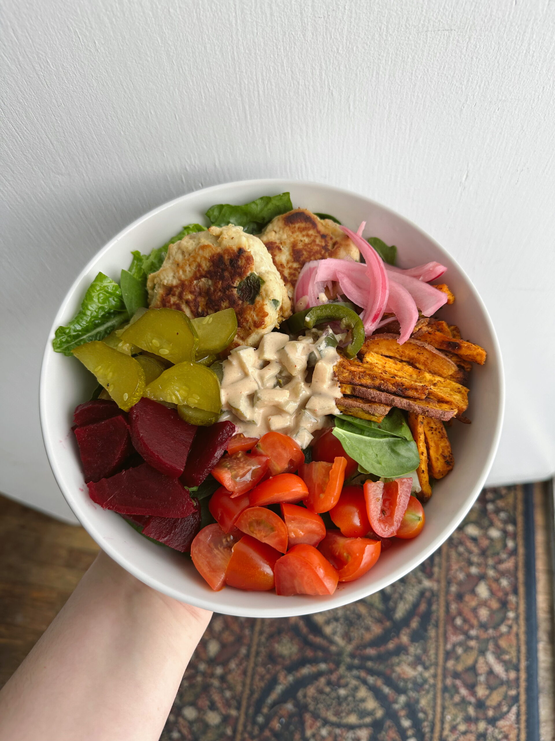 turkey burger in a bowl with vegetables and sauce